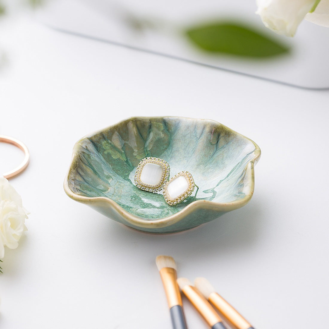 Lotus leaf ceramic trinket dish holding earrings – view 1